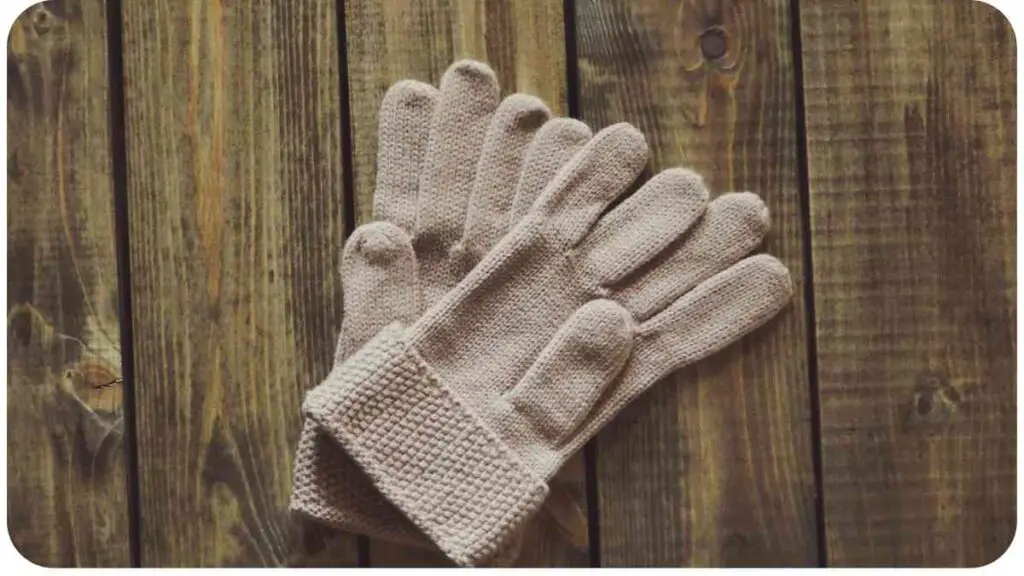 a pair of gloves laying on top of a wooden table