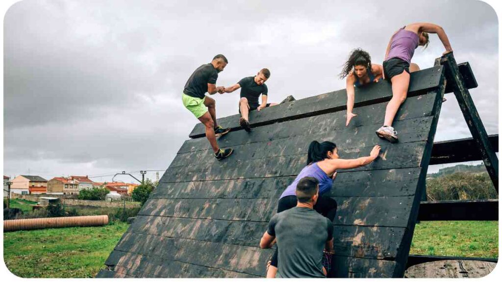 a group of people climbing on top of a wooden ramp
